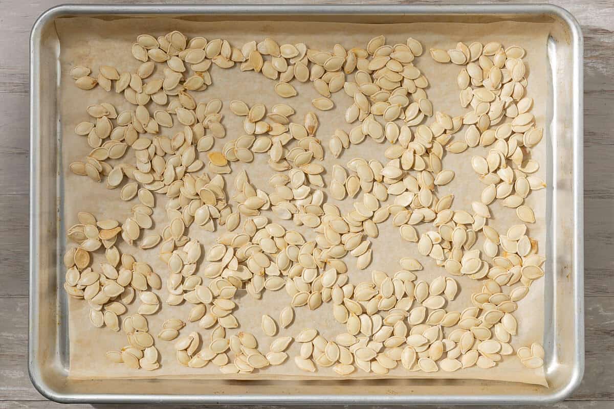 unseasoned roast pumpkin seeds on a parchment lined sheet pan.