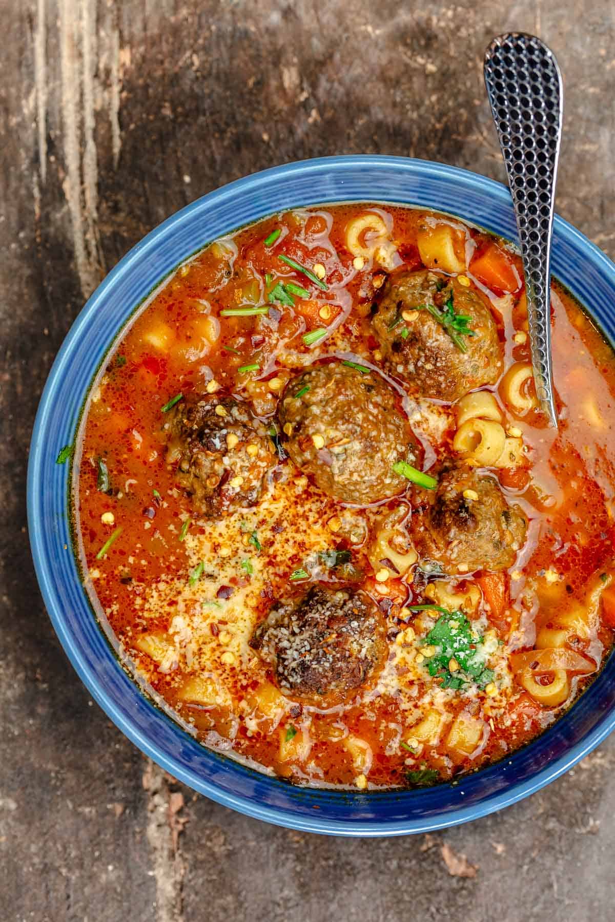 overhead photo of a bowl of meatball soup with a spoon.