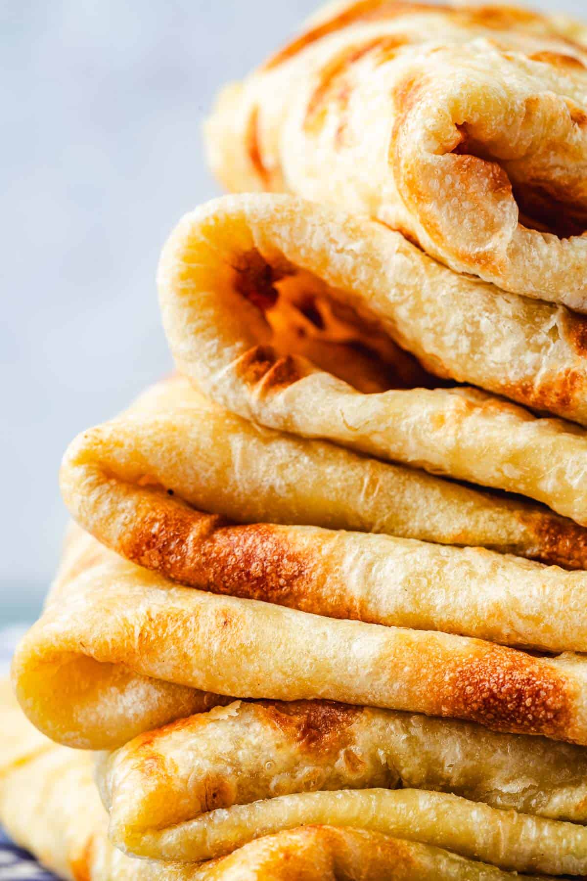 close up of a stack of folded of mlewi flatbreads.
