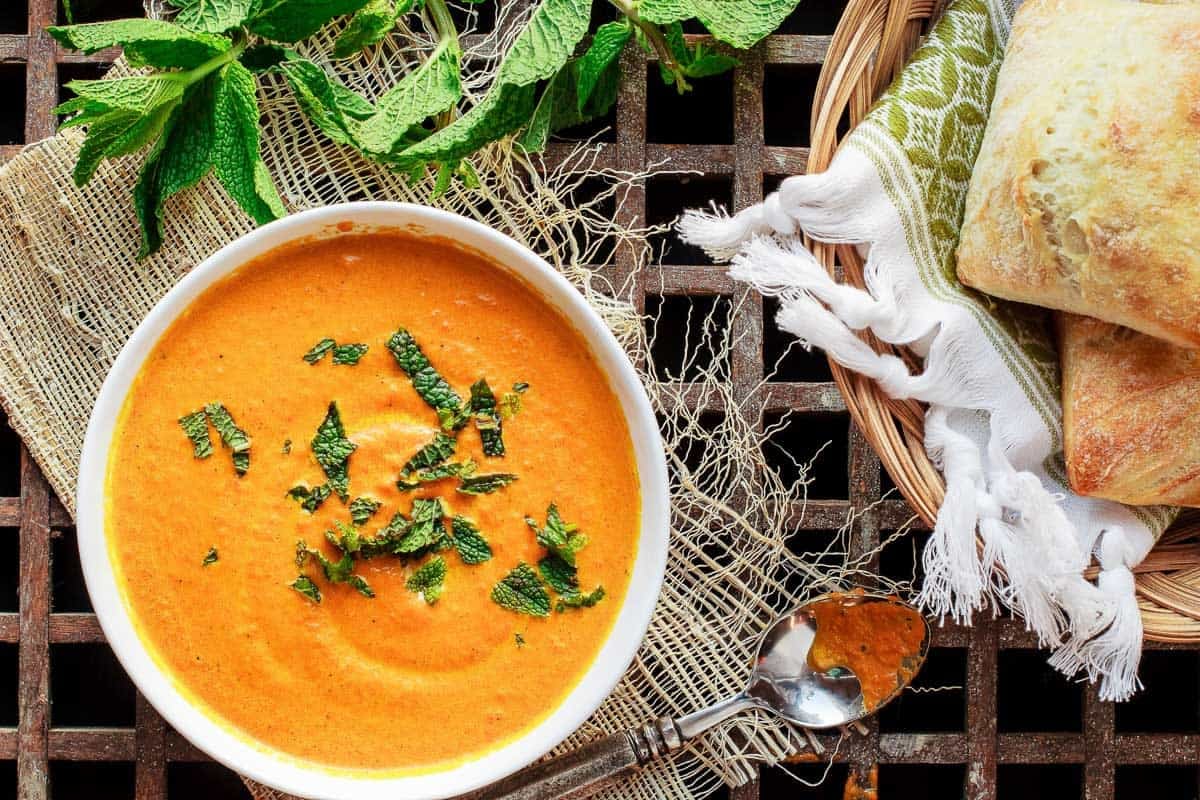 Overhead shot of roasted carrot soup with mint on top.