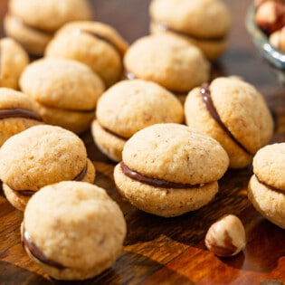 a close up of baci di dama hazelnut cookies placed on a table.