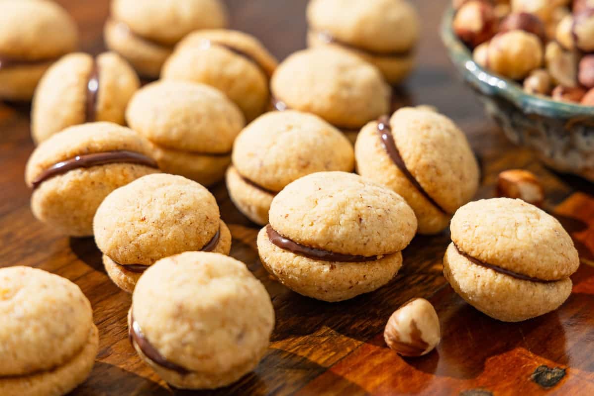 a close up of baci di dama hazelnut cookies placed on a table.