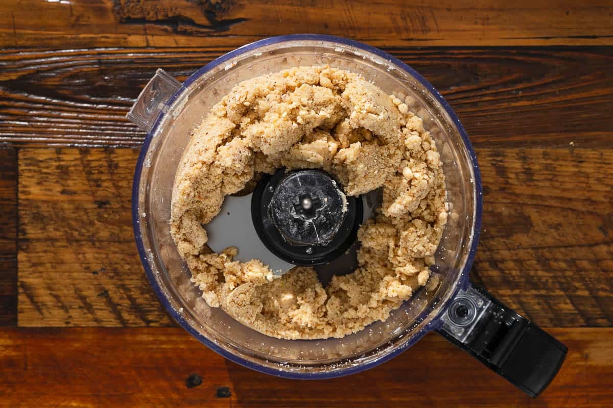 baci di dama hazelnut cookie dough in the bowl of a food processor after blending.