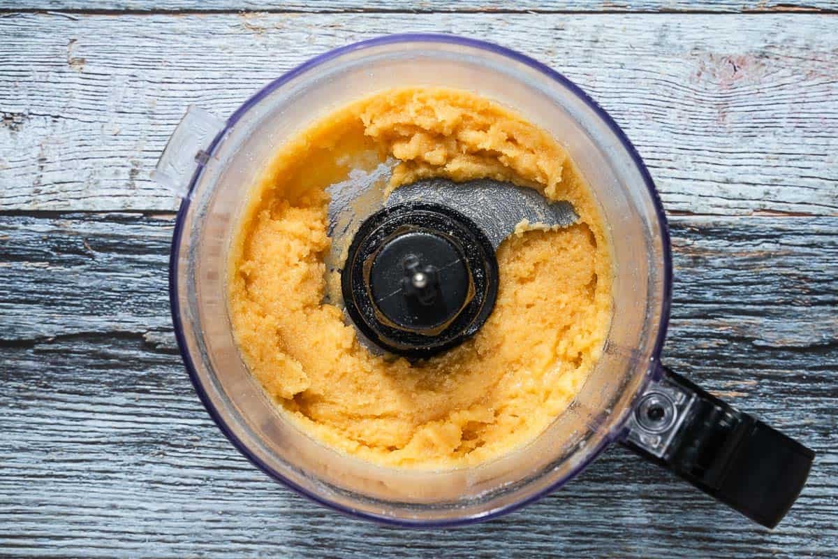 pignoli cookie dough in a bowl of a food processor.