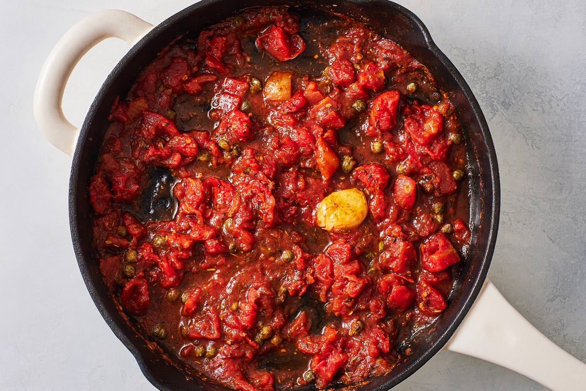 tomato sauce for the pollo alla pizzaiola chicken in tomato sauce simmering in a skillet.