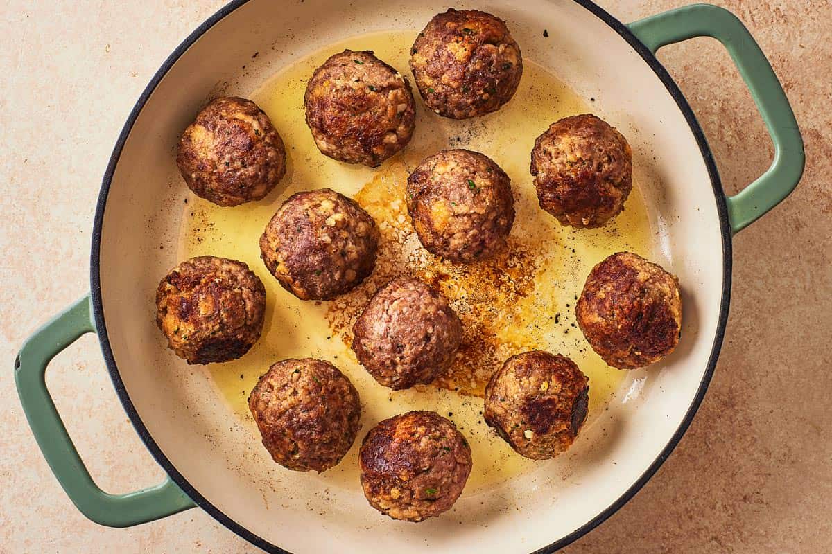 meatballs browning in a skillet.