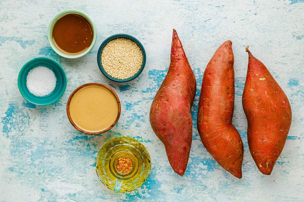 Ingredients for roasted sweet potatoes, including sweet potatoes, sesame seeds, tahini, salt, honey, and olive oil.