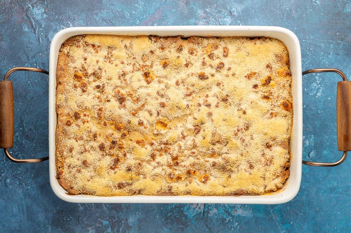 Spanakopita Mac and cheese after it has been baked in the oven, showing the golden brown edges and spots on top.