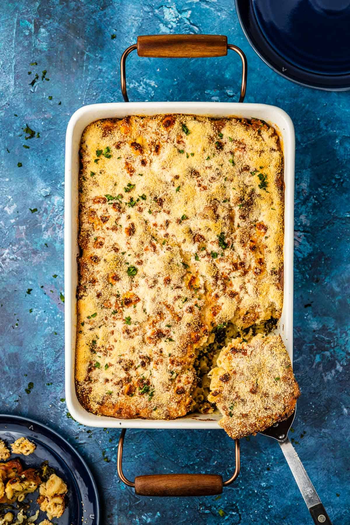 Overhead shot of a spatula removing a slice of Spanakopita Mac and cheese.