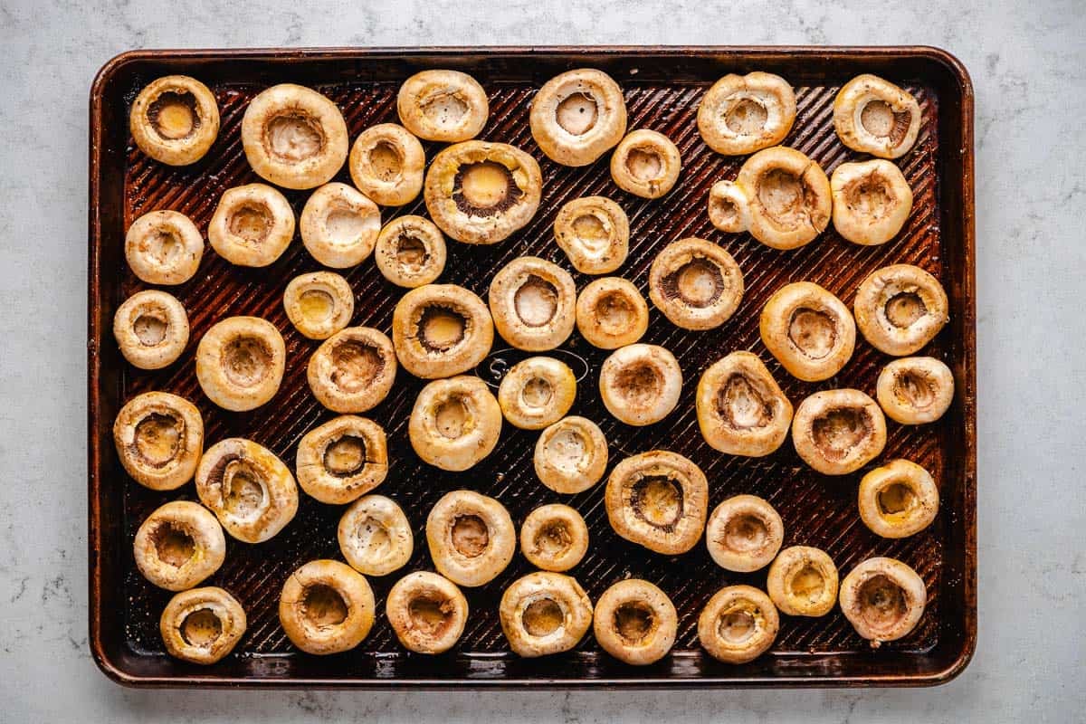 unstuffed mushroom caps on a baking sheet.