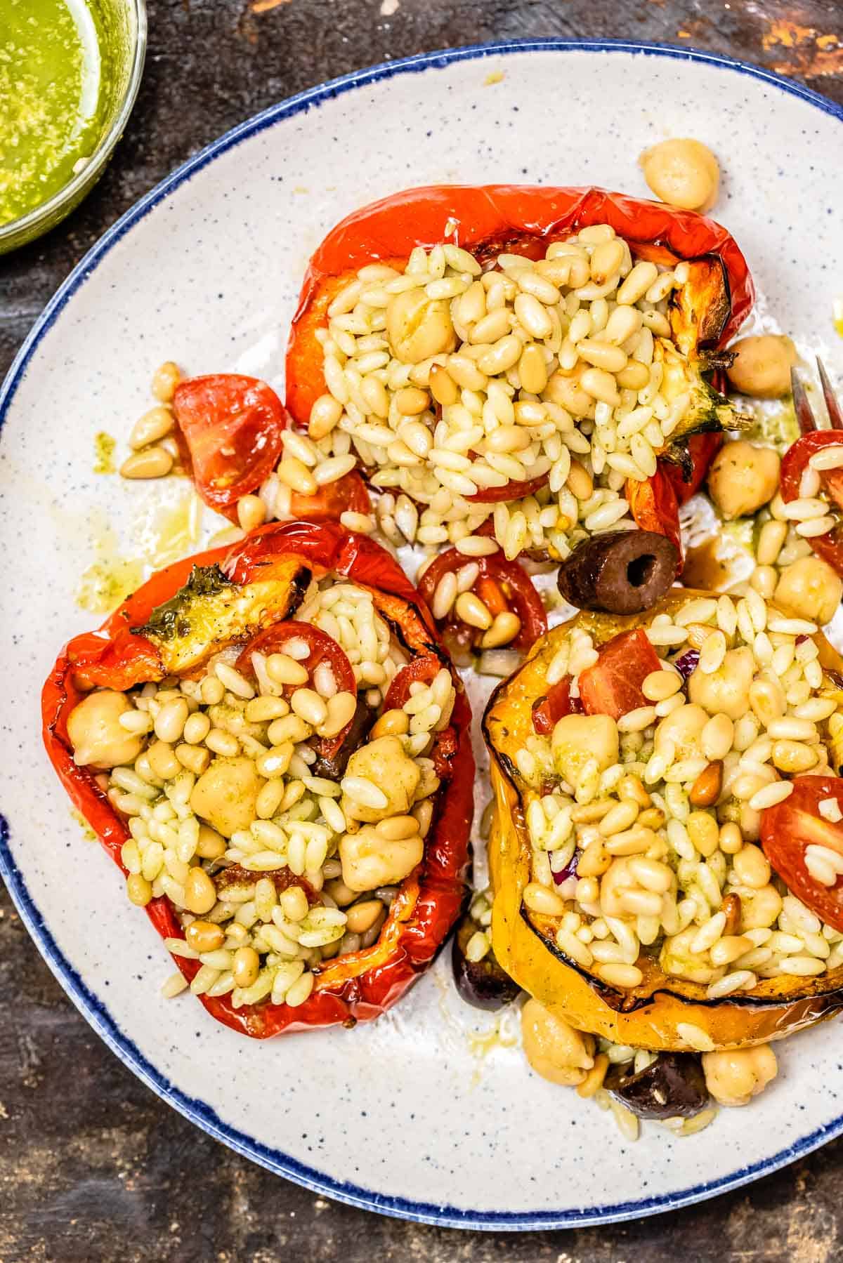 an overhead photo of three vegetarian stuffed peppers on a plate.