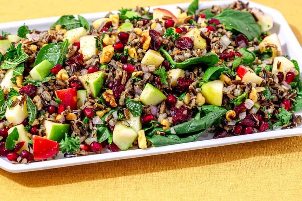 side shot of wild rice salad on a white serving platter.
