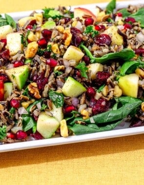 side shot of wild rice salad on a white serving platter.