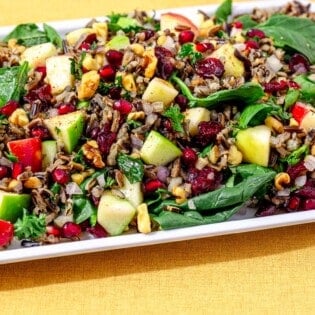 side shot of wild rice salad on a white serving platter.