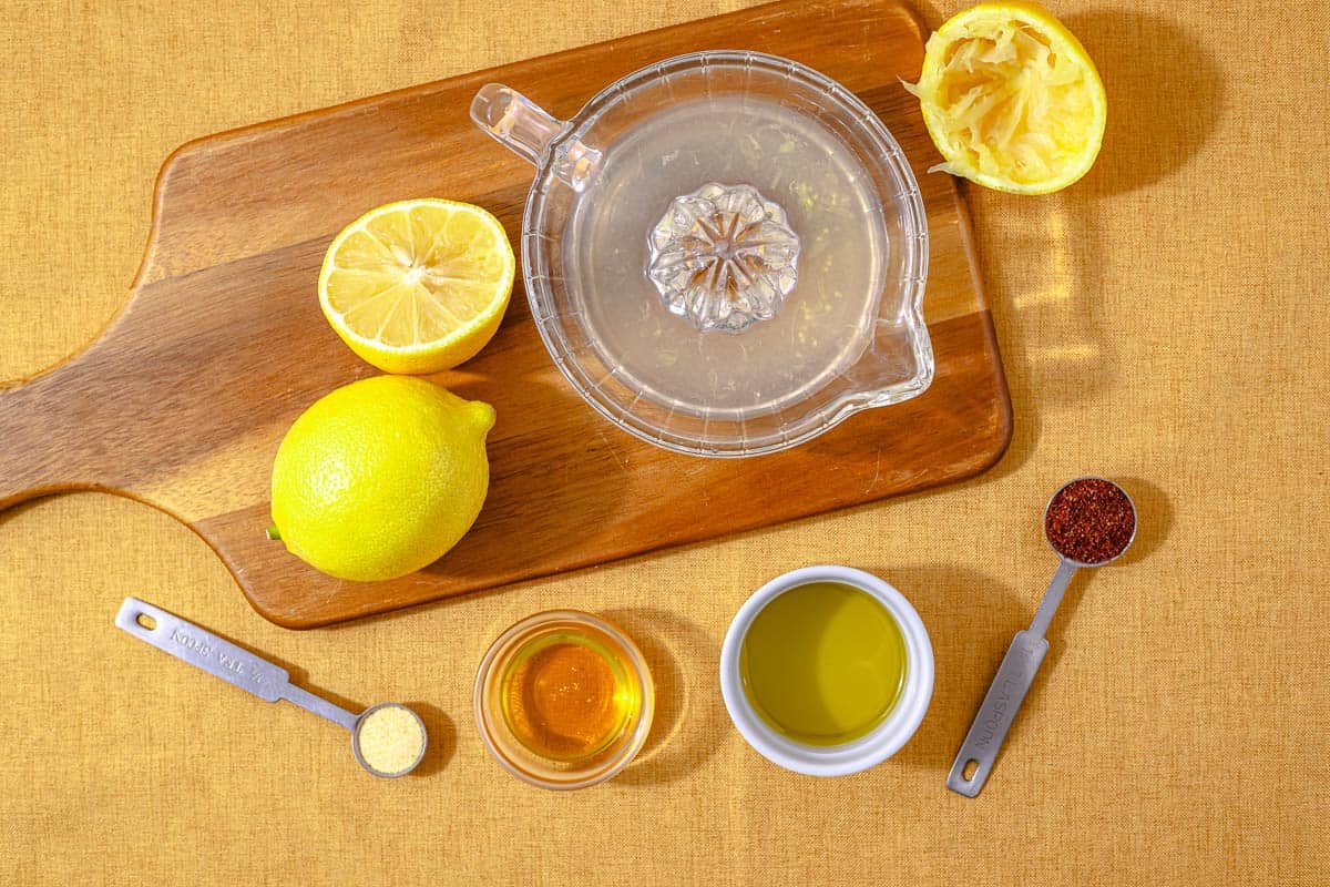 Ingredients for the wild rice salad dressing, including lemon, sumac, olive oil, honey, and garlic powder.