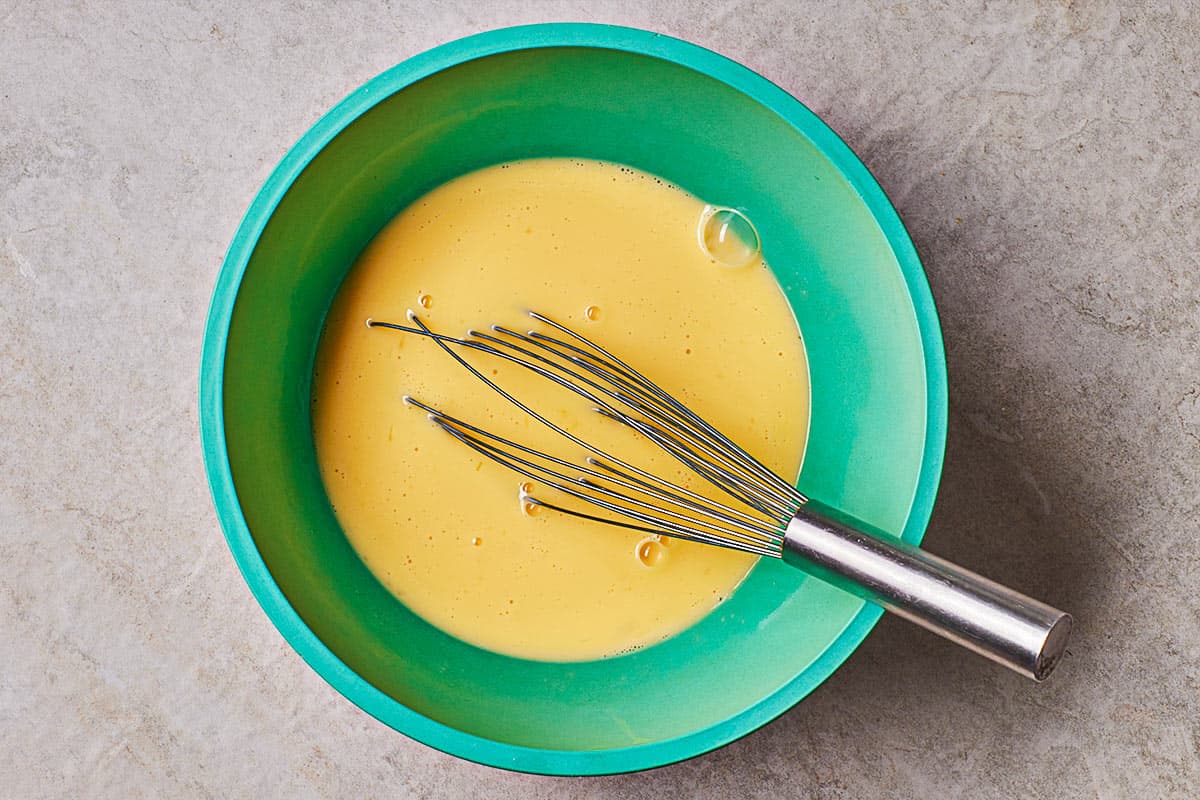 beaten eggs in a mixing bowl with a whisk.