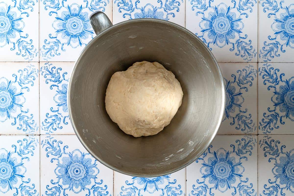 a ball of fatayer dough in the bowl of a food processor.