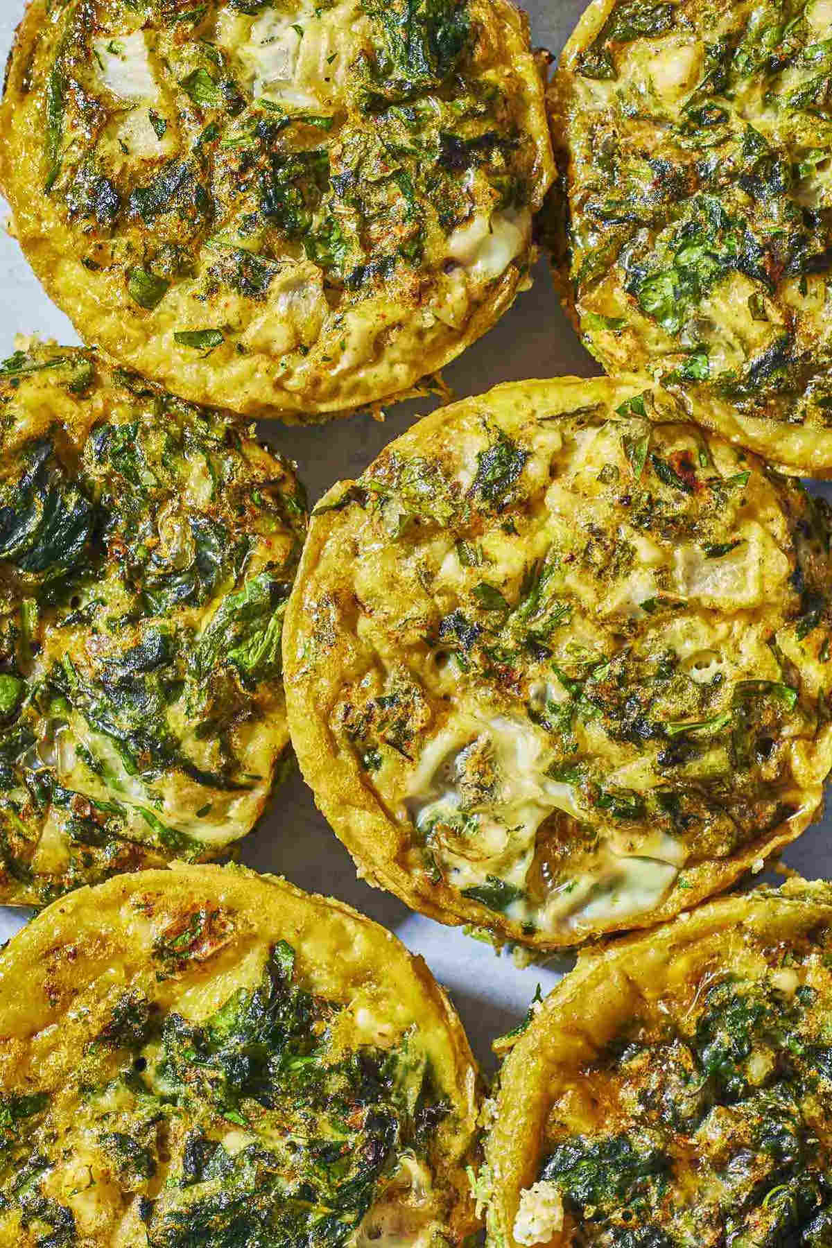 close up overhead shot of Spanakopita egg muffins, showing the herbs and spinach.
