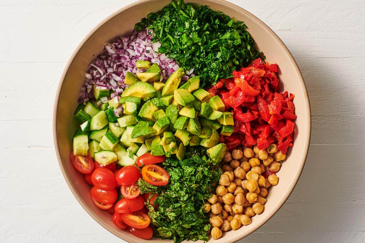 the ingredients for vegan chickpea salad in a serving bowl before being mixed together.