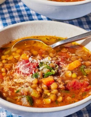 a close up of Italian lentil soup in a bowl with a spoon.