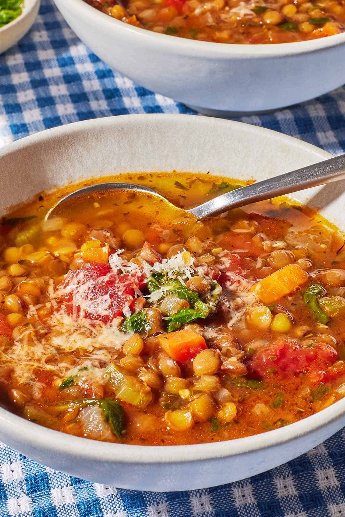 Close-up of Italian lentil soup in a bowl with a spoon.
