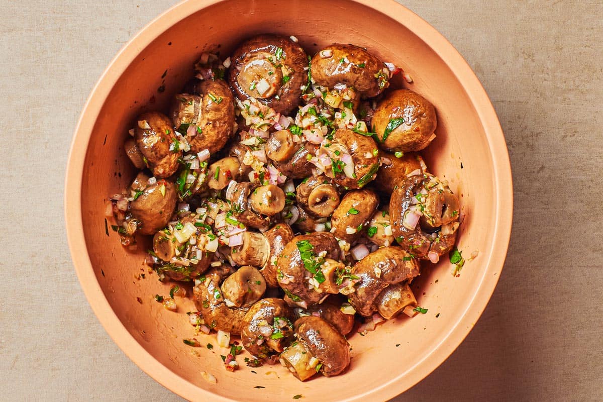 mushrooms and the marinade mixed together in a mixing bowl.