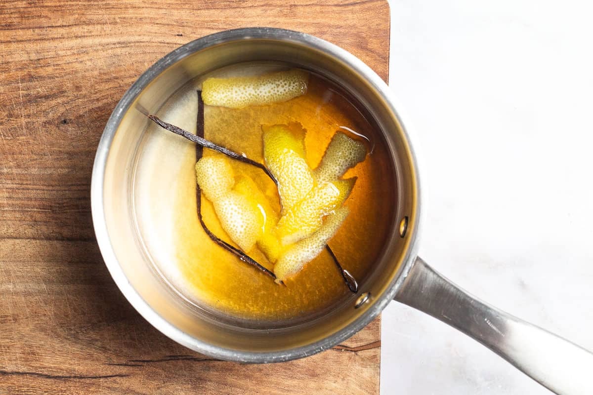strips of lemon peel and the vanilla beans simmering in a saucepan of honey, water and lemon juice.