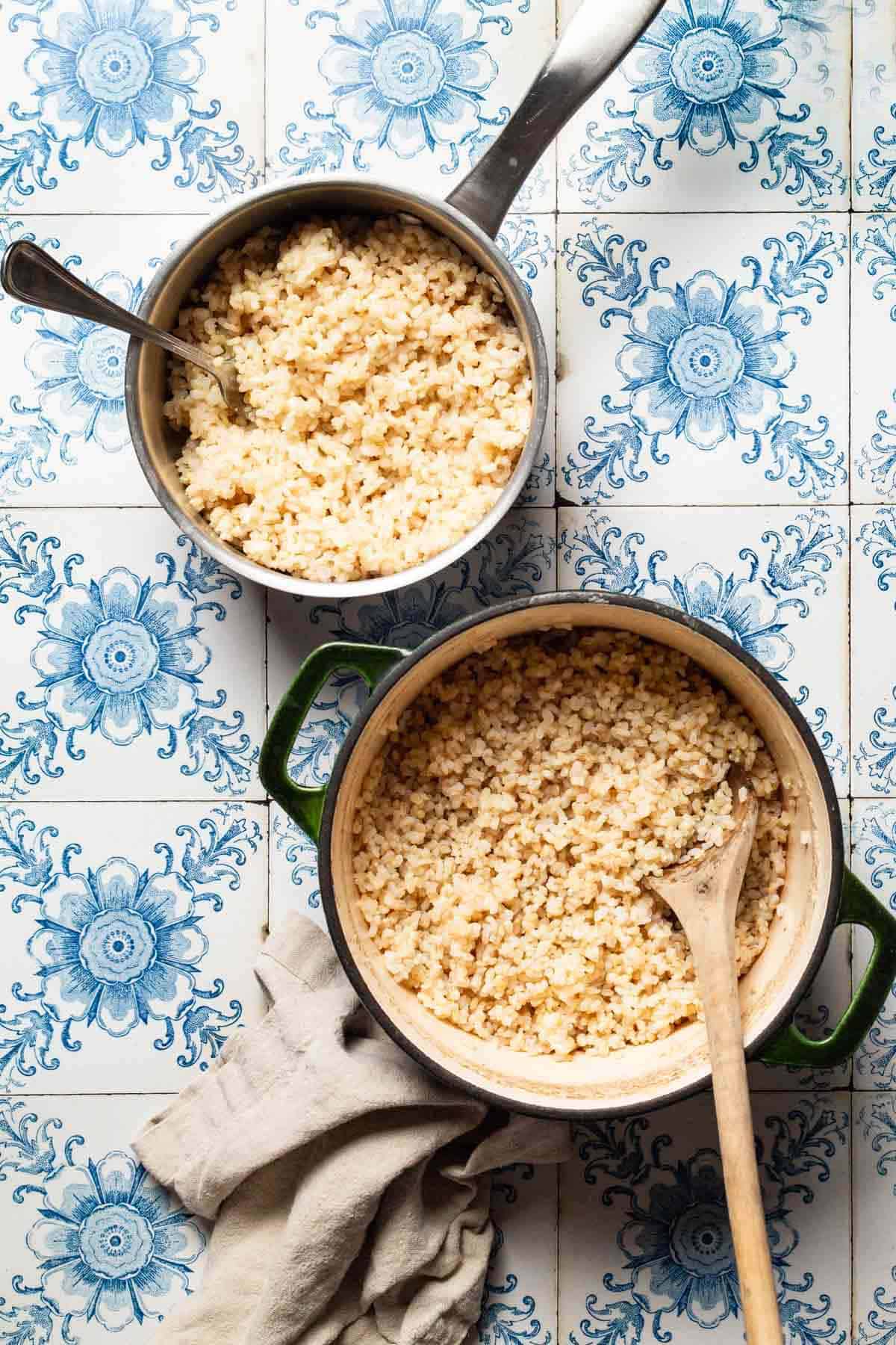 An overhead photo of brown rice in a saucepan with a spoon, brown rice in a large pot with a wooden spoon, and a cloth napkin.