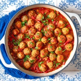 moroccan fish kofta in a large pot next to a blue cloth napkin.