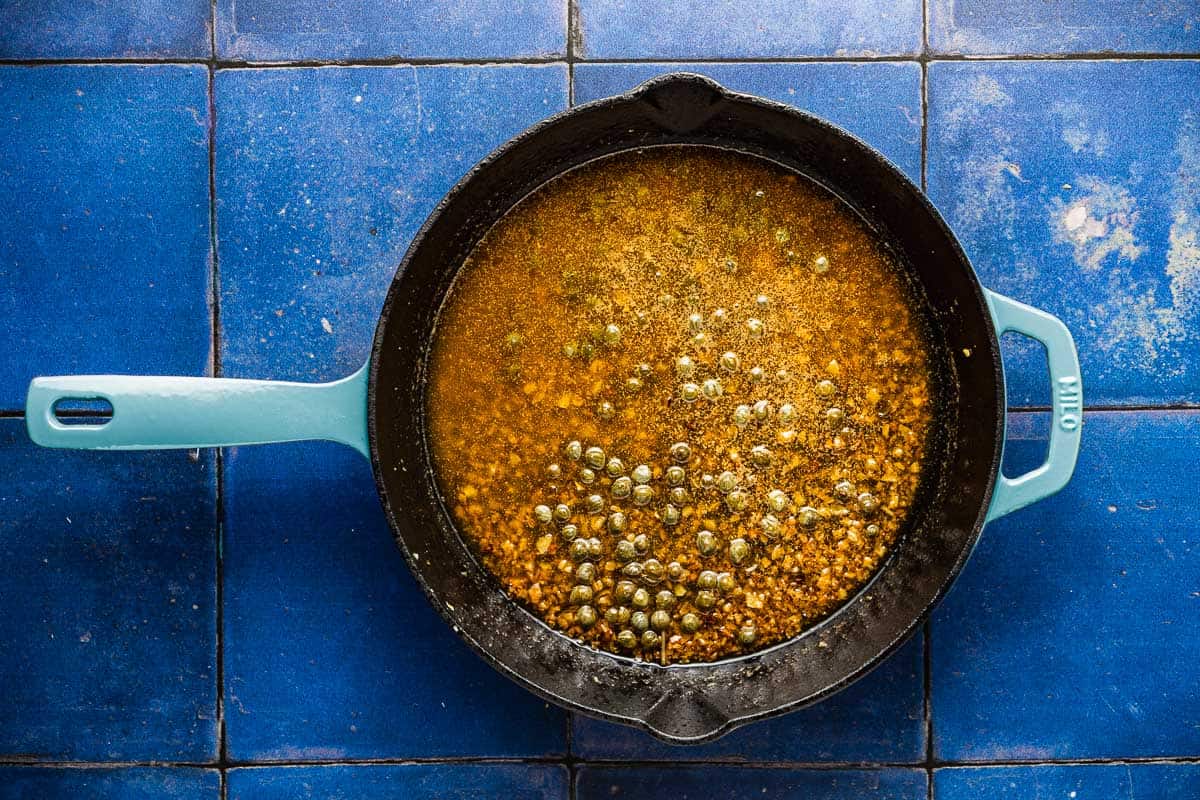 sauce for the artichoke chicken simmering in a skillet.