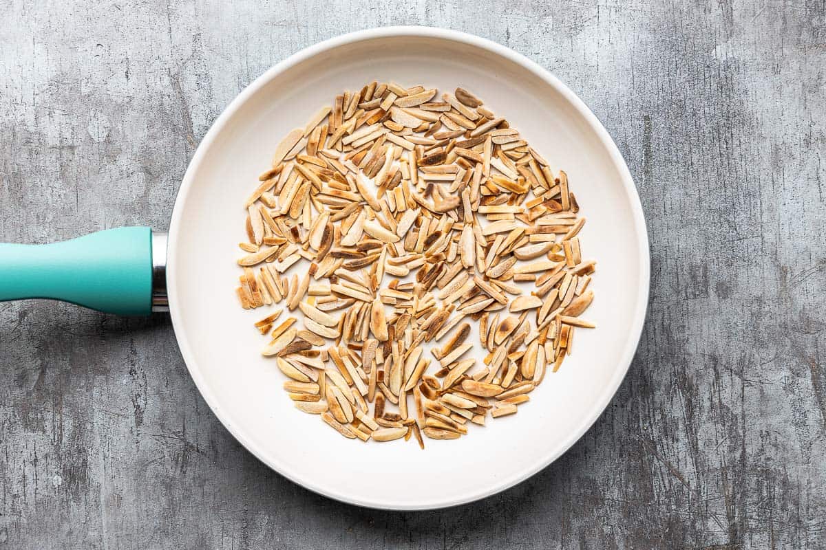 slivered almonds being toasted in a skillet.