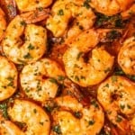 a close up of sheet pan shrimp in sauce.