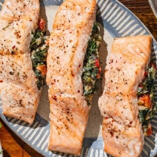 An overhead photo of three stuffed salmon fillets on a serving platter.