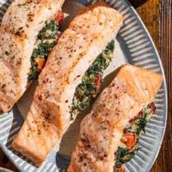 An overhead photo of three stuffed salmon fillets on a serving platter.