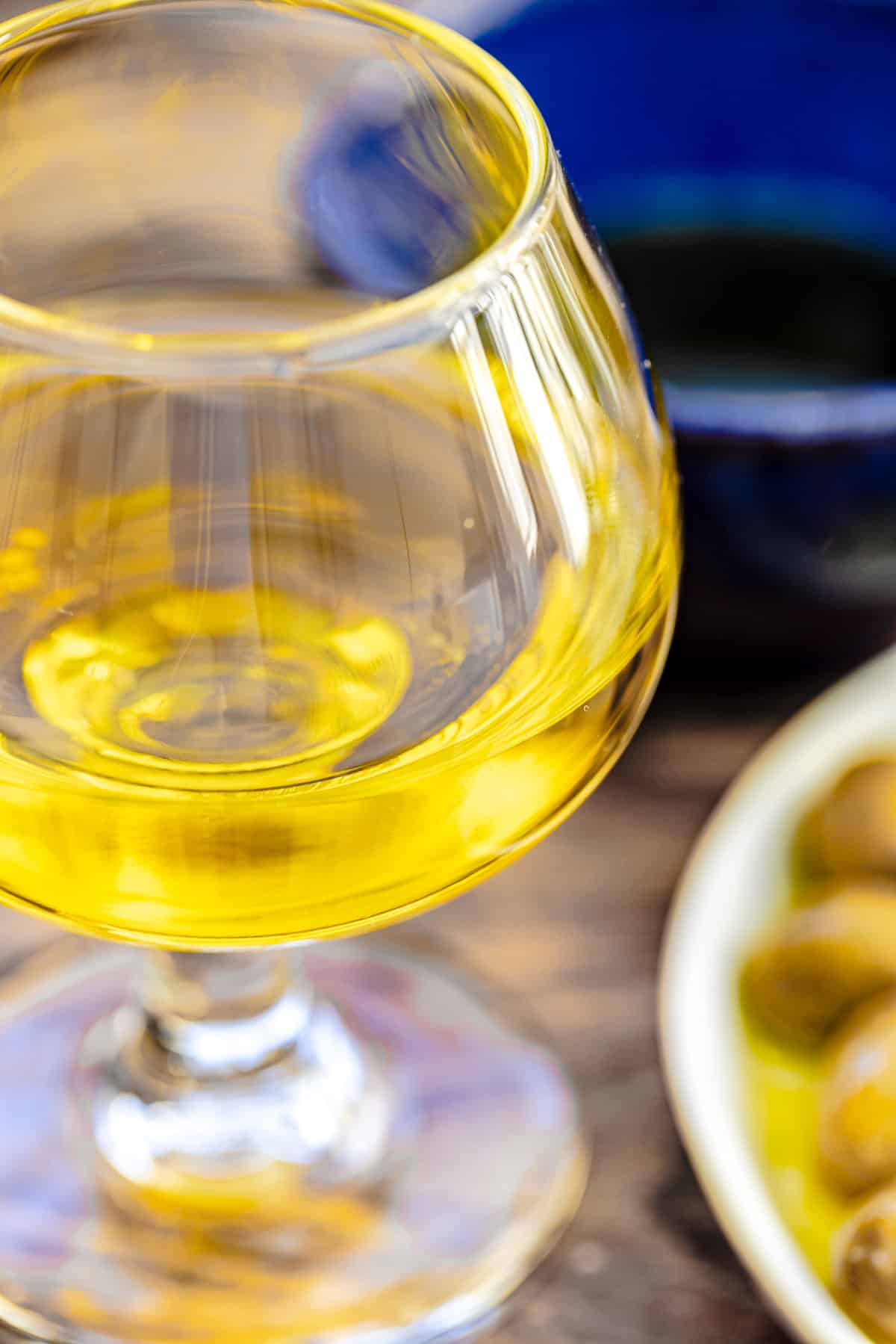a close up of a small glass of olive oil.