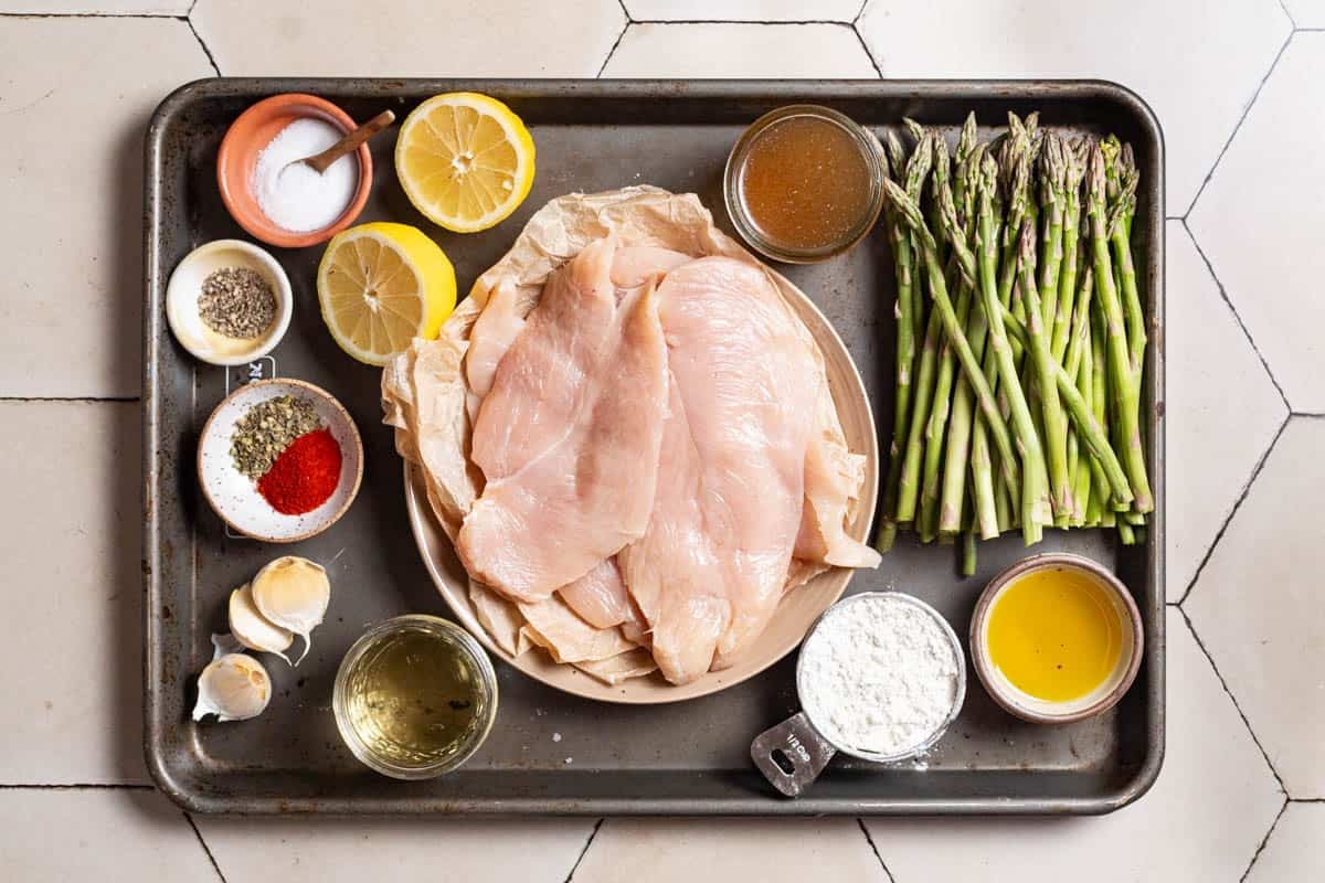 Ingredients for chicken and asparagus including chicken breast, asparagus, salt, pepper, italian seasoning, sweet paprika, flour, olive oil, garlic, white wine, lemon, and chicken broth.