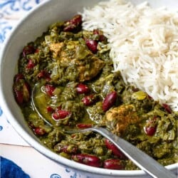 Ghormeh sabzi in a bowl with rice and a spoon.