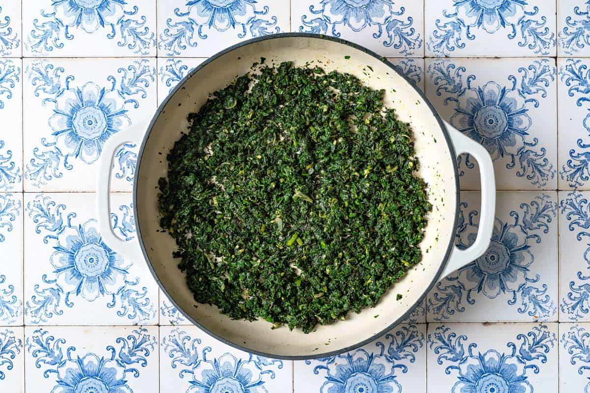 The herbs for the ghormeh sabzi being fried in a skillet.