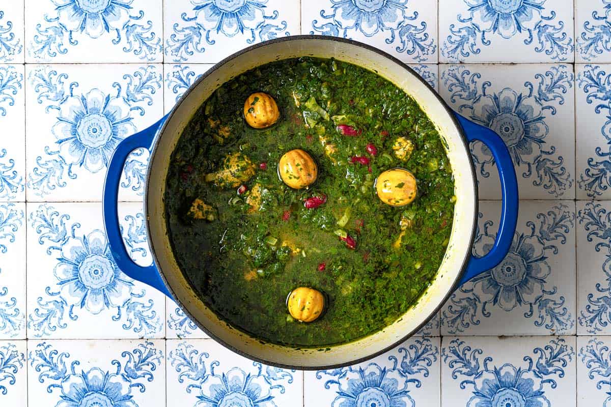 Ghormeh sabzi simmering in a large pot.