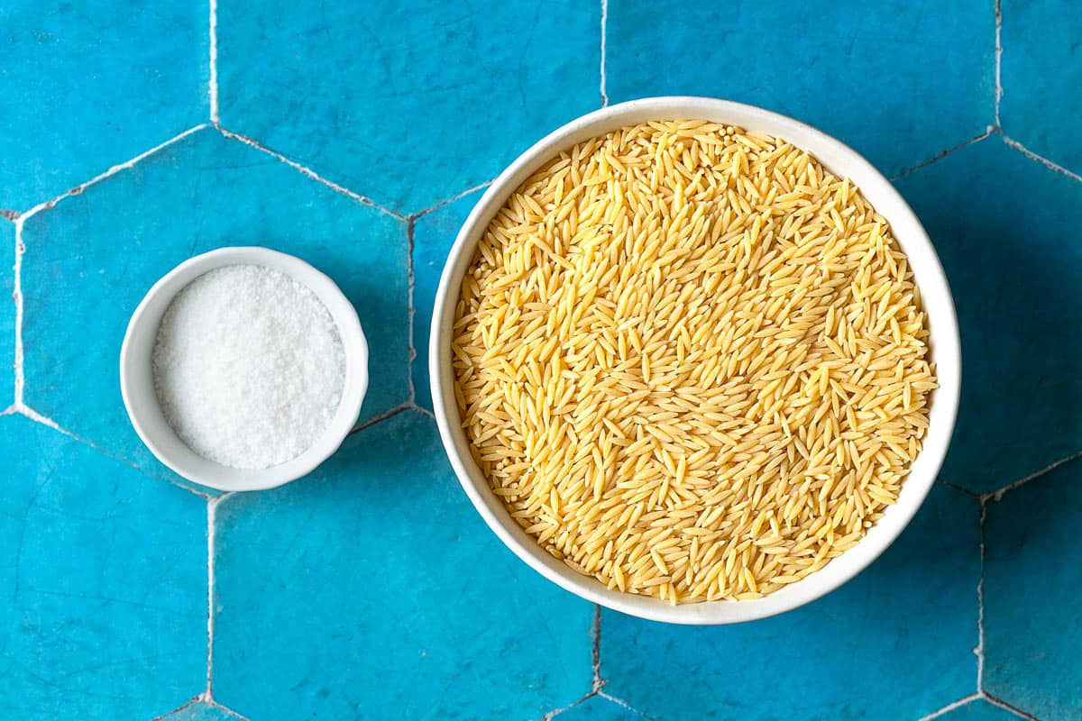 Ingredients for how to cook orzo including orzo pasta and salt.