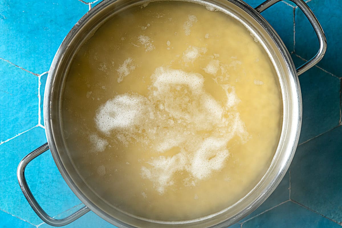 Orzo boiling in a pot of salted water.