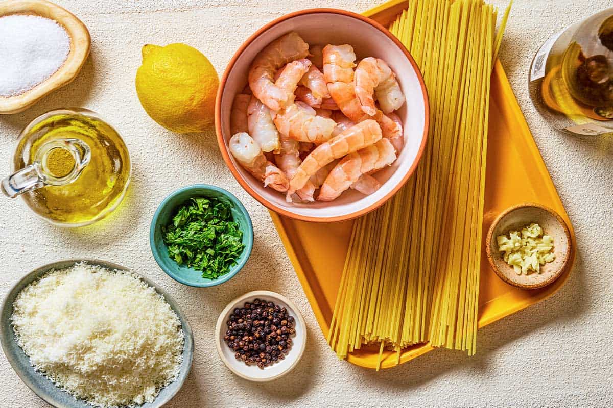ingredients for shrimp cacio e pepe shrimp, spaghetti, salt, peppercorns, olive oil, garlic, white wine, lemon, grated pecorino romano cheese, and parsley.
