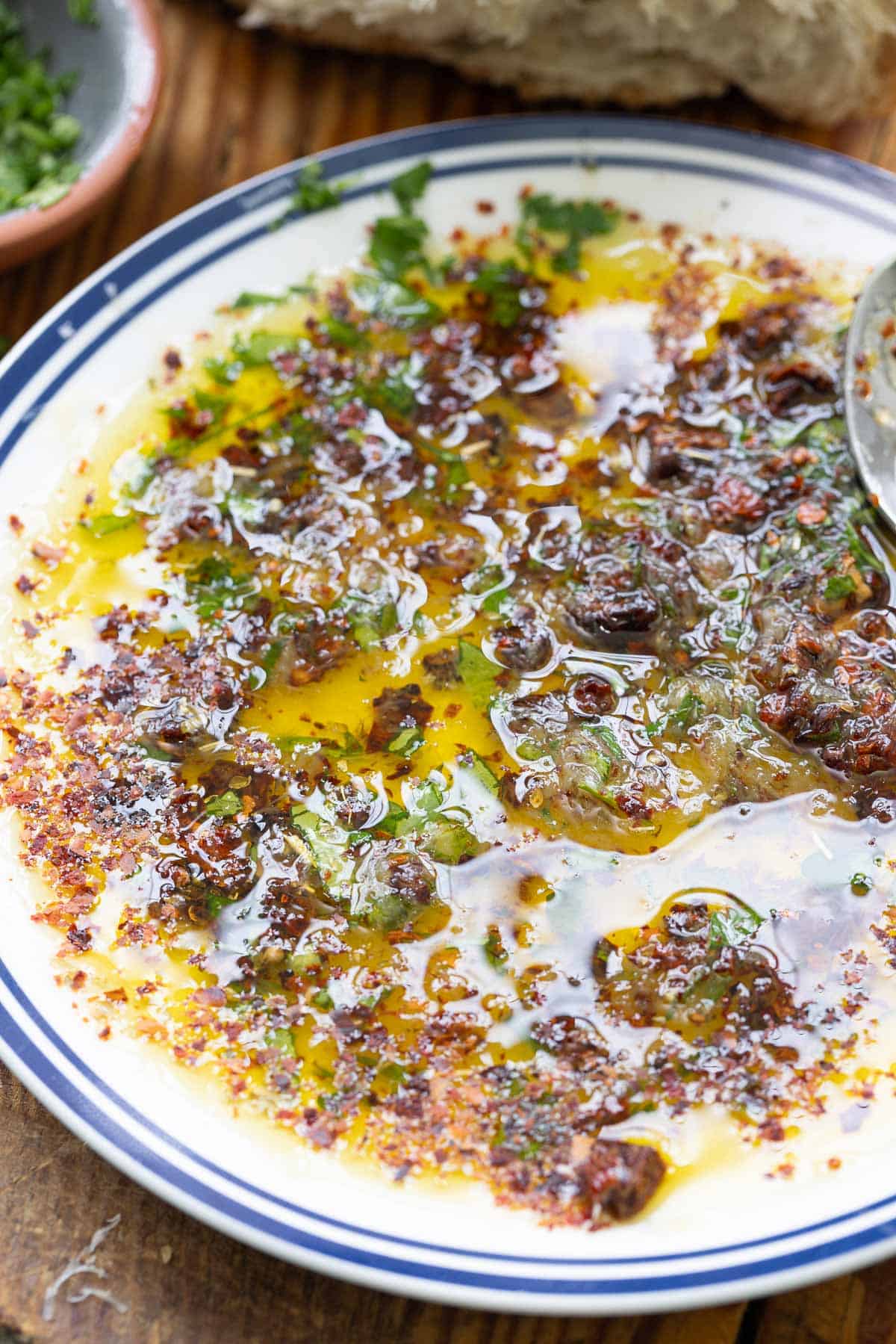 A close up of bread dipping oil on a plate.