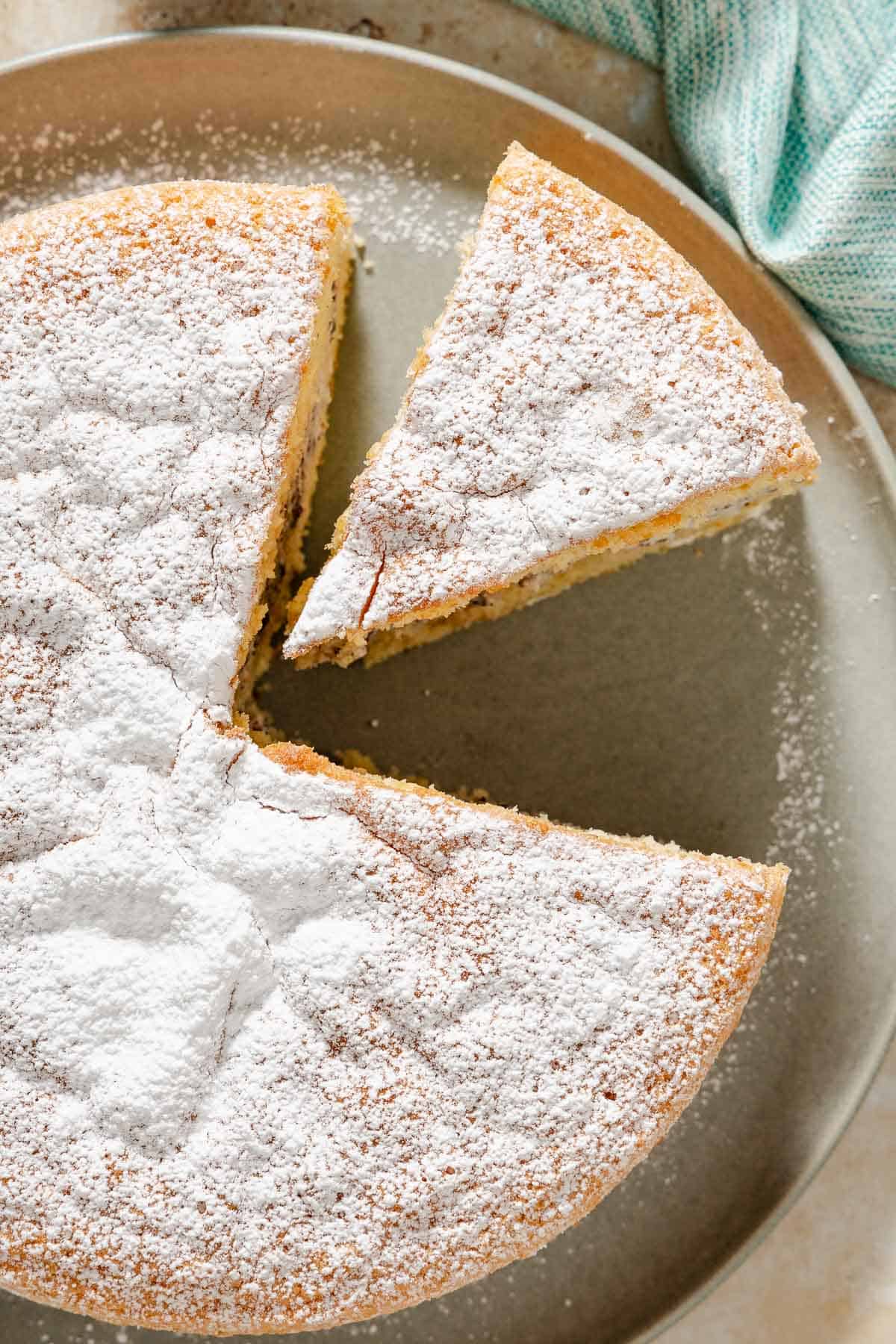 An overhead close up photo of the easy cassata cake on a platter with a slice cut and separated from it.