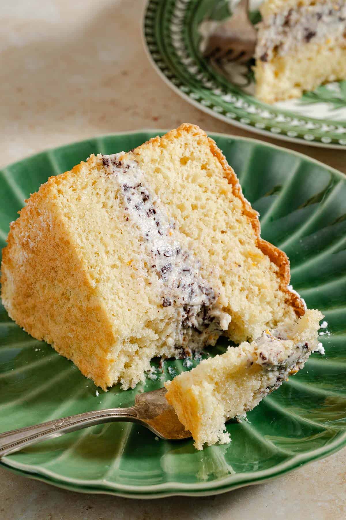 A slice of the cassata cake on a plate with a bit of it sitting on a fork.