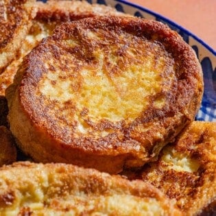 A close up photo of several torrijas on a serving platter.