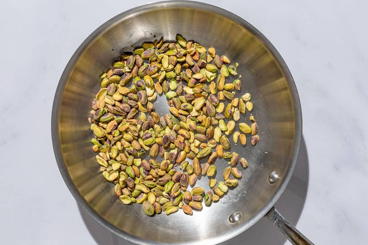 Pistachios being toasted in a skillet.