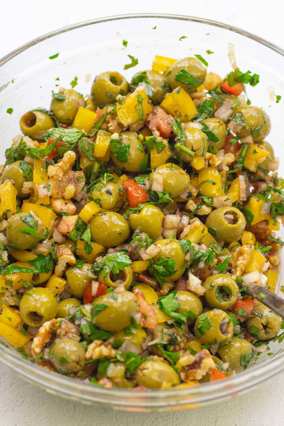 A close up of olive salad in a mixing bowl.