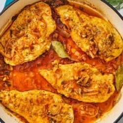 An overhead photo of braised chicken breasts in a skillet.