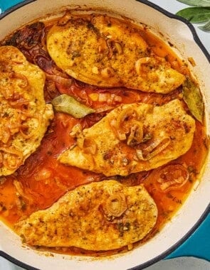 An overhead photo of braised chicken breasts in a skillet.